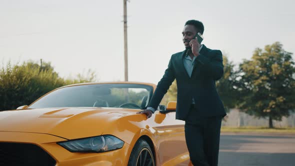 Serious African Man in Business Suit Holding Modern Smartphone on Hand While alt