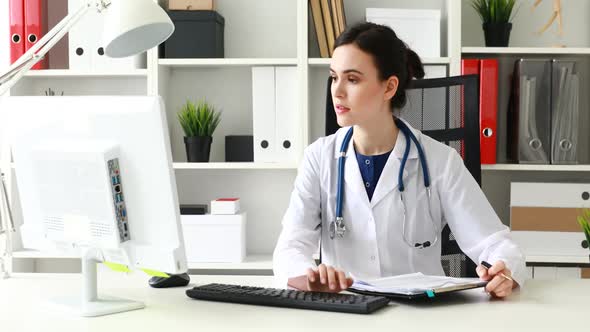 Doctor Working at Computer in Bright Office