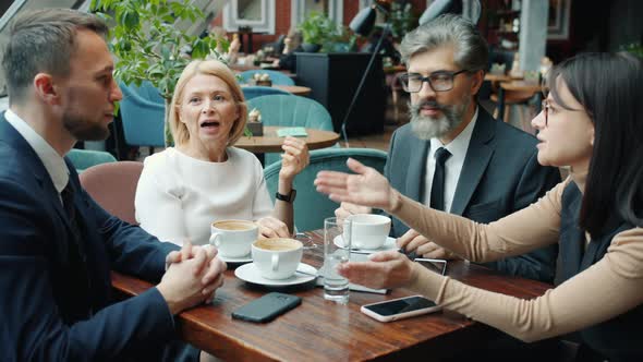 Colleagues Men and Women Talking in Cafe During Business Lunch Discussing Work alt