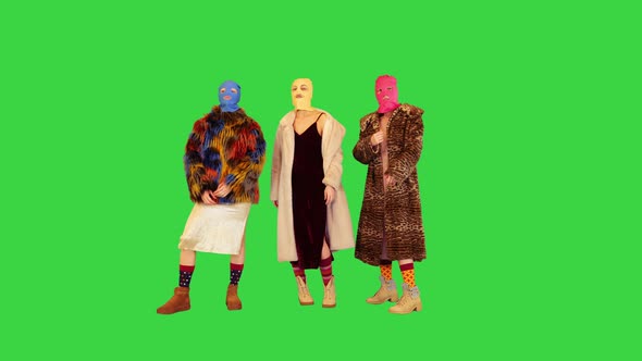 A Group of Girls in Colored Balaclavas Pose in Fashionable Manner on a Green Screen Chroma Key