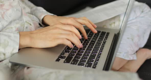 freelance or Businesswoman sitting at home and typing on a laptop hands close up. work during quaran