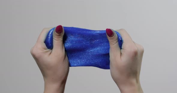 Woman Hands Playing with Oddly Satisfying Blue Slime Gooey Substance. Antistress alt