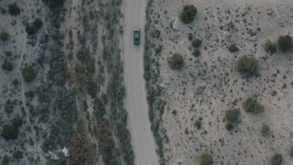Drone shot of truck driving through desert. Drone shot of truck driving down dirt road. Vehicle driv alt