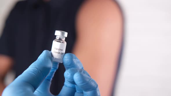 Hand in Latex Gloves Holding Glass Ampoule Vaccine with Copy Space alt