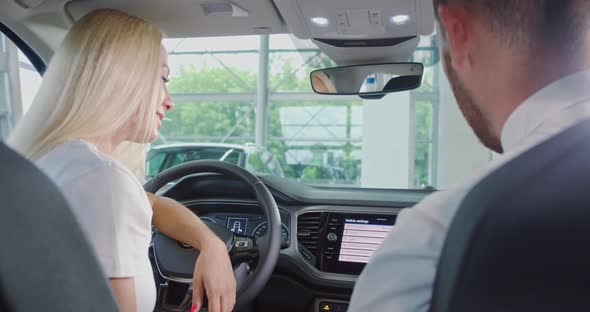 Woman Having Consultation with Salesman While Choosing Car alt