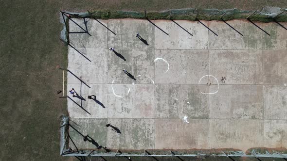 Aerial View of Group of Kids Seen Playing Soccer on Concrete Slab