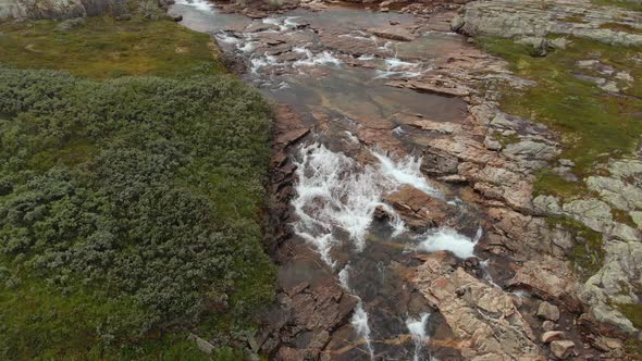 Glacial meltwater river flowing in Norway Hardangervidda landscape, aerial view alt