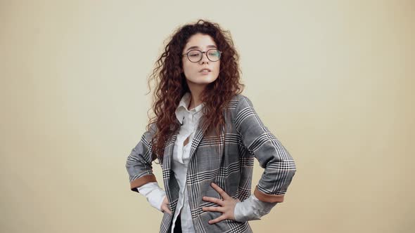 The Arrogant Young Woman Confident with Her Hands in the Middle in Profile Looks Into the Room alt