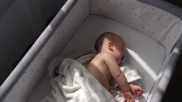 Top View Face of Newborn Nnaked Sleeping Little Small Infant Baby Boy Lying On Side On Soft White alt