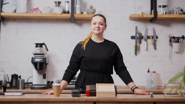 Confident Smiling Plussize Woman Standing at Cafe Counter Looking at Camera alt