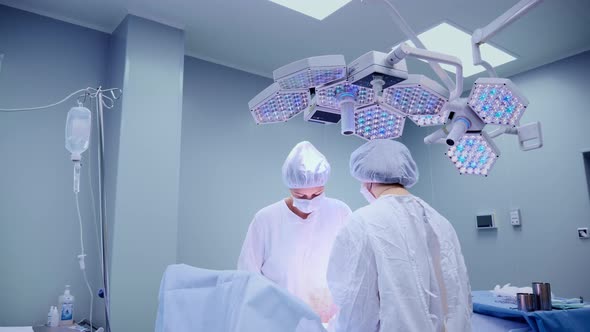 Medical Team Performing Surgical Operation in Bright Modern Operating Room alt