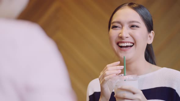 young attractive asian female smiling  positive conversation with friend at cafe
