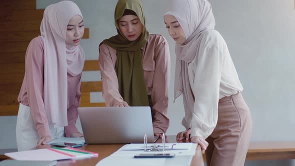 Upwardly mobile Asian Muslim business entrepreneur SME start up group of young man and women, discus alt