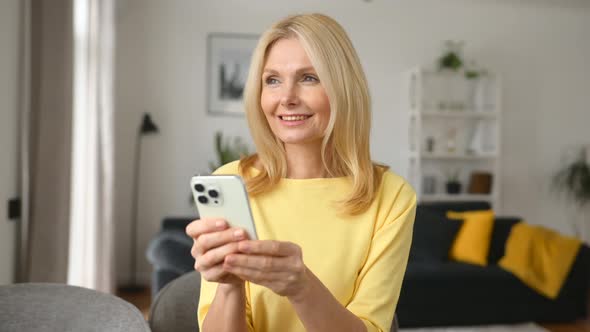 Charming Optimistic Middleaged Woman Using Smartphone