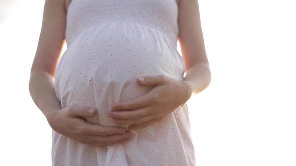 Young Pregnant Woman with Large Belly Posing Outdoors