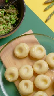 Vertical Flat Lay Video the Cook Puts Plate of Cooked Potato Dumplings