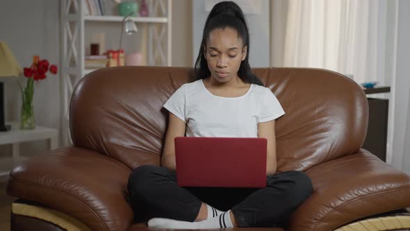 Wide Shot Front View of Confident Young Freelancer Sitting on Comfortable Armchair Surfing Internet alt