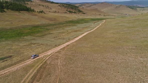 Aerial Footage Filmed with Drone of Pickup Car Riding in Steppe. the Car Travels Along the Steppe To alt
