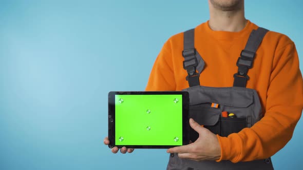 Close Shot of Repairman Hands Holding a Tablet with Green Screen. alt