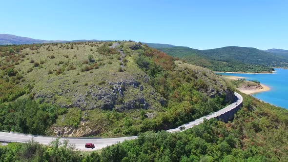 Aerial view of paved road passing artificial lake of Peruca, Croatia alt