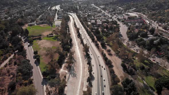 Drone flies above busy freeway filled with cars in Downtown Los Angeles