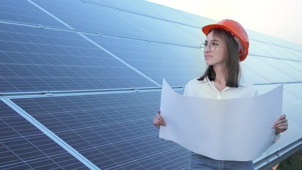 Handsome Architect Woman Examining a Draft Map or Blueprint Project Plan alt