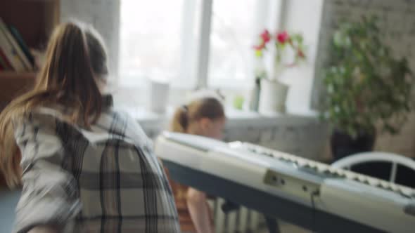 A Girl Plays with a Music Teacher After a Synthesizer Lesson alt