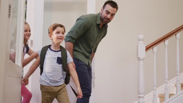 Caucasian family entering the front door of their house alt