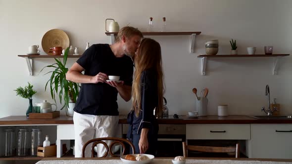 Young Woman Is Kissing Her Husband on Kitchen at Sunday Morning, Breakfast Time alt