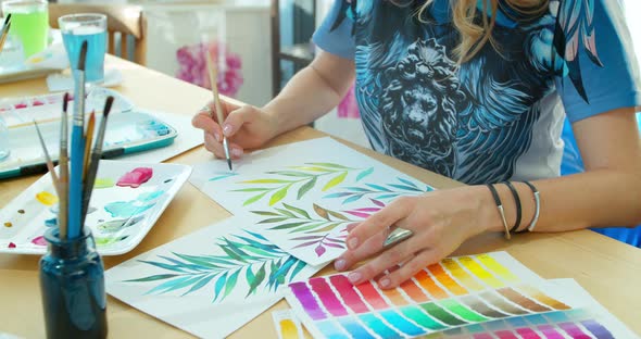 The Artist Paints Flowers. Watercolor Drawing. Hand Drawing with a Brush. Female Hand with a Brush alt