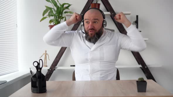 Excited Smiling Caucasian Doctor with Headphones Celebrating Success Raising His Hands Winning alt