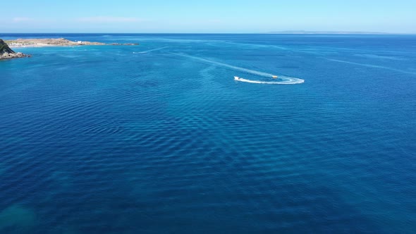 Aerial View of a Motor Boat Towing a Tube. Zakynthos, Greece