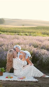 Beautiful Young Other with a Little Daughter on a Picnic in the Field alt