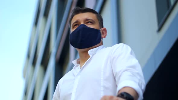 Low angle view of Young businessman Men in protective mask in the city. COVID-19