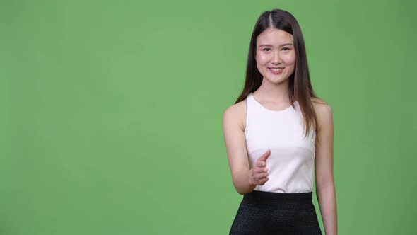 Young Beautiful Asian Businesswoman Giving Handshake
