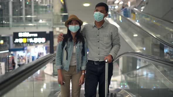 Couple Asian people walking in airport terminal waiting for  flight boarding.