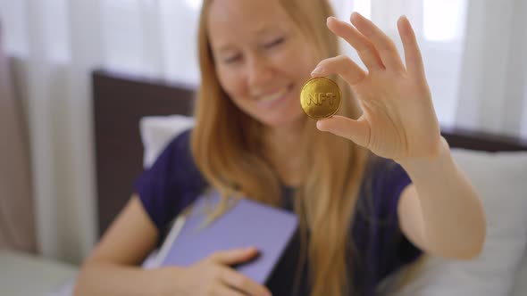 Woman Digital Artist Contemporary Painter Hold an NFT Coin in Her Hand alt