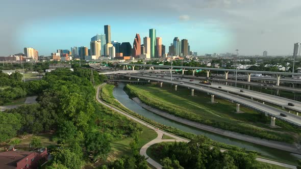 Houston skyline and Interstate 45. Dramatic golden hour light. Descending aerial of beautiful colorf alt