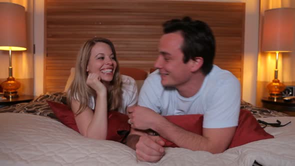 Couple laying on bed together alt