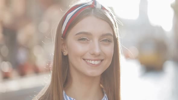 Close Up Portrait of Young Good Looking Girl with Brown Hair and Headband Wearing in Striped Dress alt