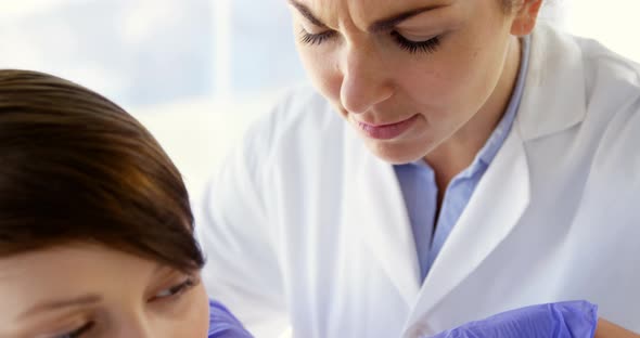 Woman therapist pointing a mole of her patient alt