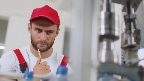 Young Man Worker of Water Factory Checking Quality and Making Inspection in Line Production