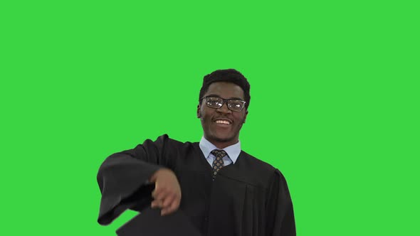 Excited African American Male Student Throwing Mortarboard in the Air and Making Silly Dance alt