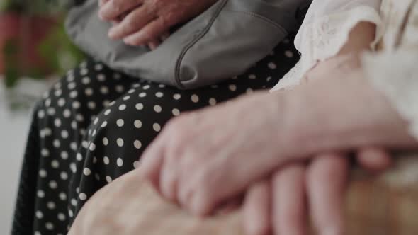 Low View of Unrecognizable Grandmothers Sitting with Folded Hands alt
