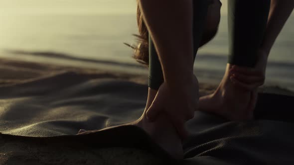 Flexible Sportswoman Bending Body to Feet on Beach Closeup alt
