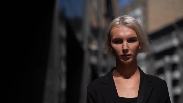 Androgynous Model Is Walking in City at Summer Day, Masculine and Feminine Face Features alt