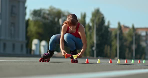 Roller Skater Makes a Marking of the Track Puts Cones on the Asphalt alt