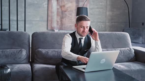 A Professional Sits in a Beautiful Dark Office in Front of a Laptop alt