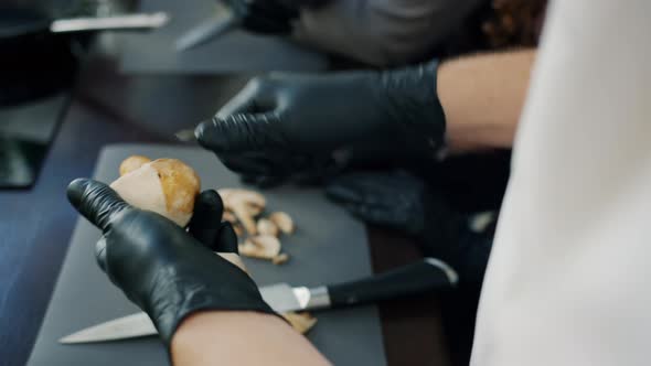 Close-up of Man's Hands in Gloves Cooking Food Peeling Mushrooms Using Knife alt