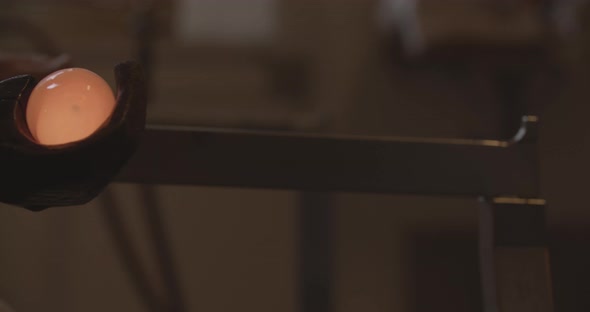 Professional glassblower working with glass at the workshop alt